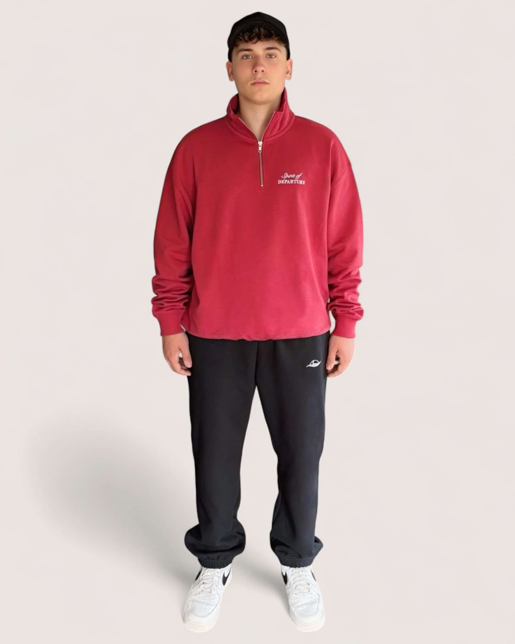 Man wearing Heavy Essential Sweatpants | Black paired with a red quarter-zip sweatshirt.