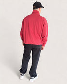 Person wearing Heavy Essential Sweatpants | Black paired with a red fleece jacket and cap from the back.