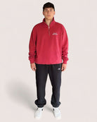 Man wearing Heavy Essential Sweatpants | Black paired with a red quarter-zip sweatshirt.